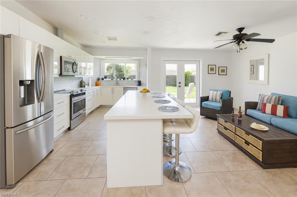 5010 31st Avenue Southwest Naples, FL 34116 - Photo 33 of 33 a living room with stainless steel appliances furniture and a kitchen view