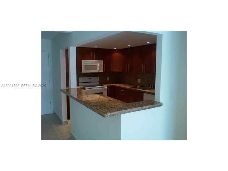 150 Southeast 25th Road, Unit 8L Miami, FL 33129 - Photo 3 of 12 a kitchen with a sink and a microwave