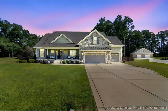 a front view of a house with a garden and trees