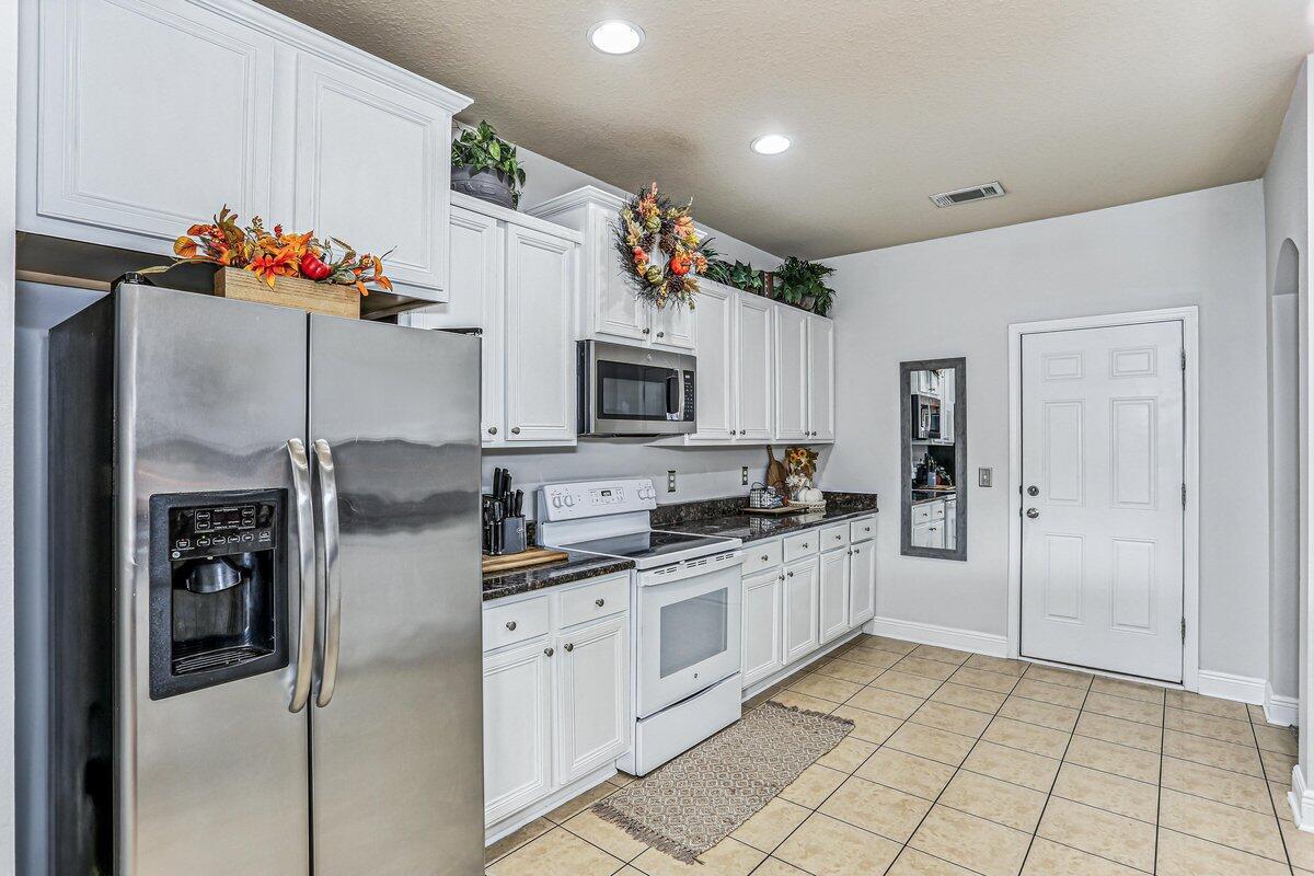 405 Pendo Place Crestview, FL 32536 - Photo 12 of 39 a kitchen with granite countertop a refrigerator and a sink