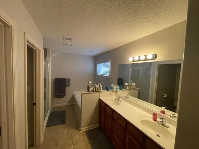 an empty room with a chandelier fan and windows