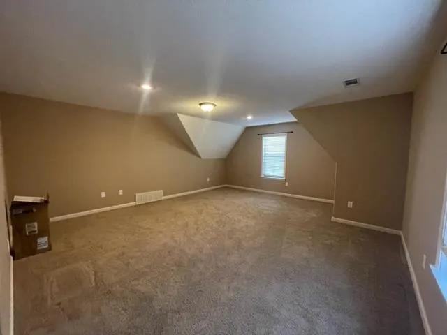 an empty room with a ceiling fan and a window