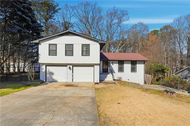 a front view of a house with a yard and trees