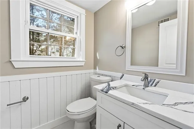 a bathroom with a sink toilet and a mirror