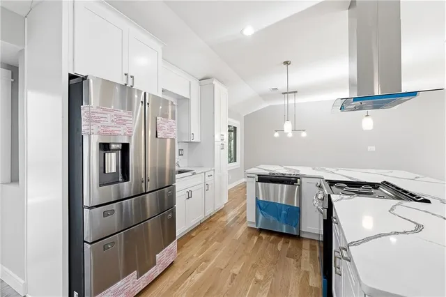 a kitchen with stainless steel appliances granite countertop a refrigerator a stove and a wooden floors