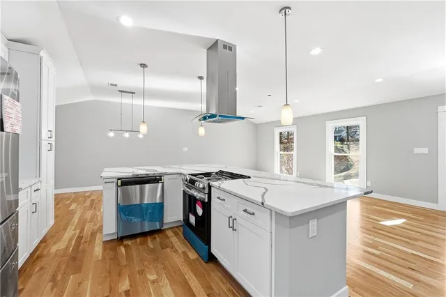 a kitchen with stainless steel appliances granite countertop a stove a sink and a refrigerator