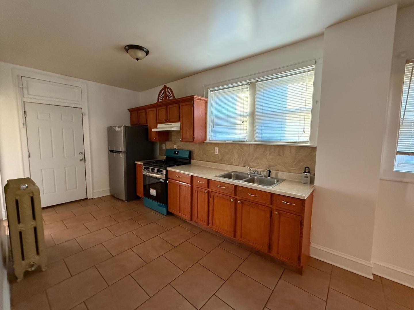 7749 South Indiana Avenue, Unit 1 Chicago, IL 60619 - Photo 5 of 13 a kitchen with stainless steel appliances granite countertop a sink and a stove