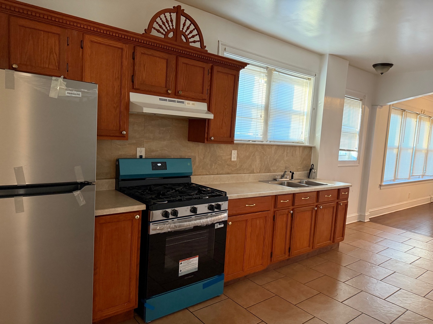 7749 South Indiana Avenue, Unit 1 Chicago, IL 60619 - Photo 8 of 13 a kitchen with wooden cabinets and a stove top oven