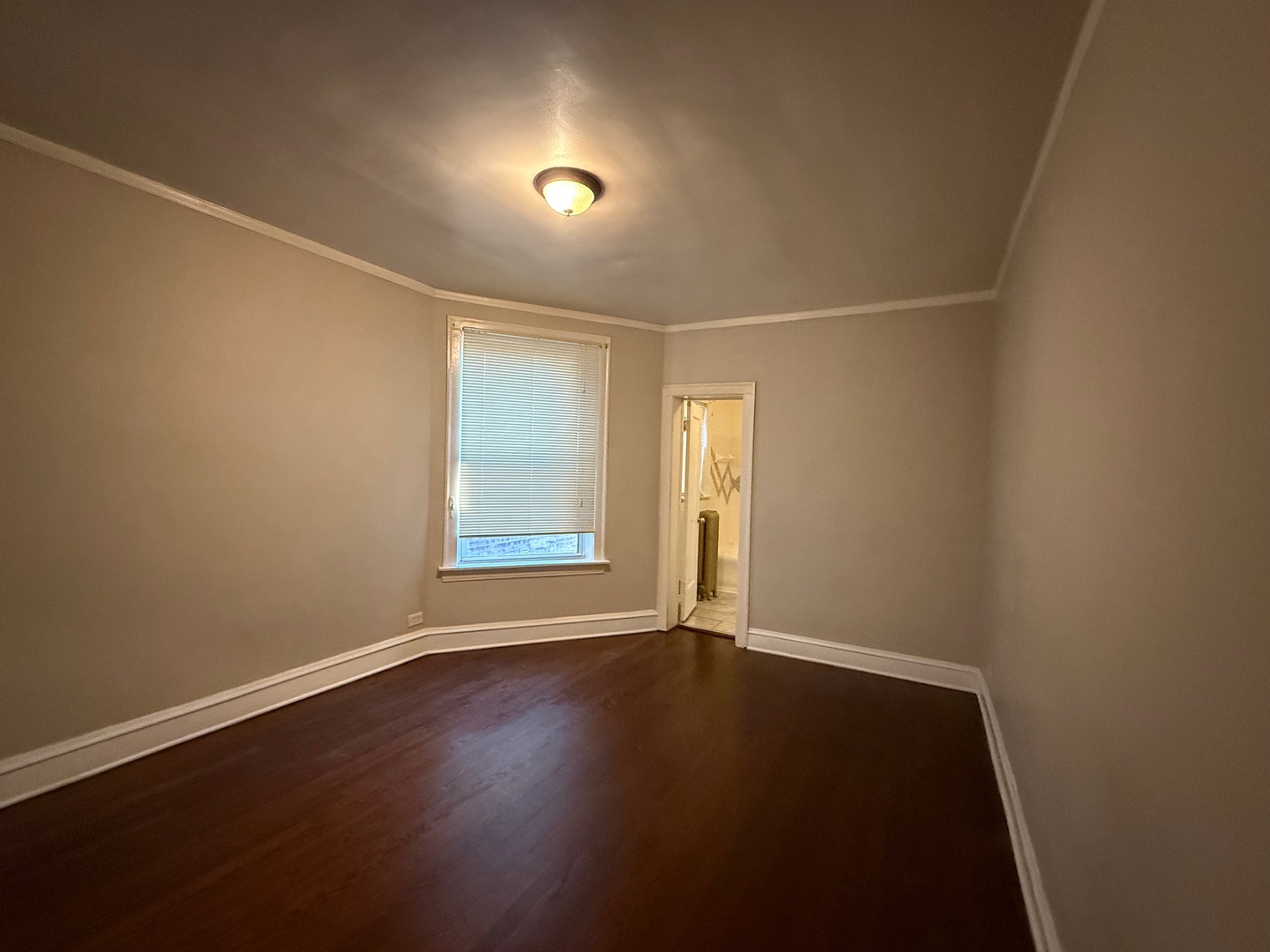 7749 South Indiana Avenue, Unit 1 Chicago, IL 60619 - Photo 9 of 13 an empty room with wooden floor and windows
