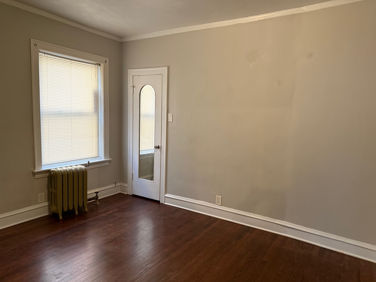 7749 South Indiana Avenue, Unit 1 Chicago, IL 60619 - Photo 10 of 13 an empty room with wooden floor and windows