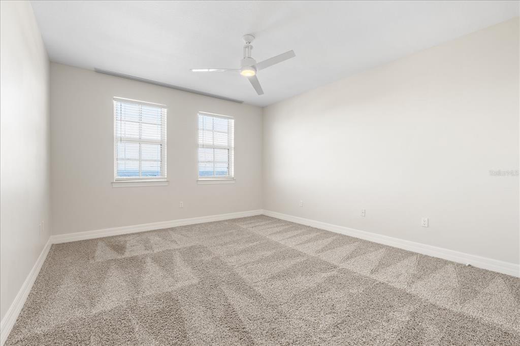 536 Bahia Beach Boulevard, Unit 428C Ruskin, FL 33570 - Photo 9 of 30 an empty room with windows and chandelier fan