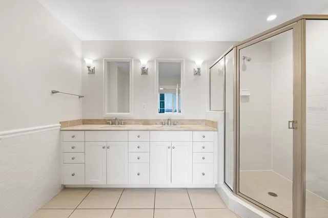 a bathroom with a granite countertop sink a mirror and a shower