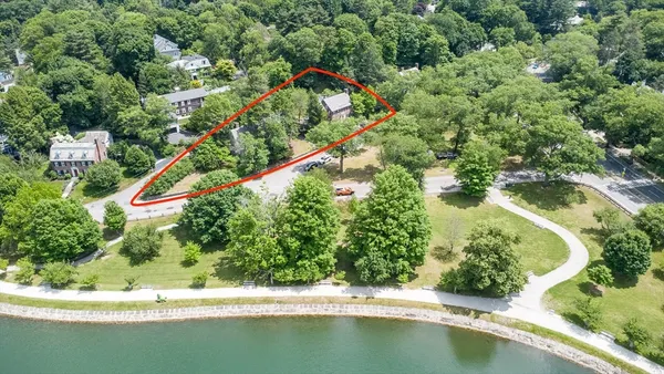 an aerial view of a house with a yard and lake