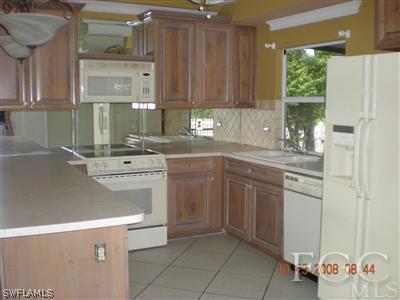 17160 Lee Road Fort Myers, FL 33967 - Photo 3 of 10 a kitchen with a sink a stove and cabinets