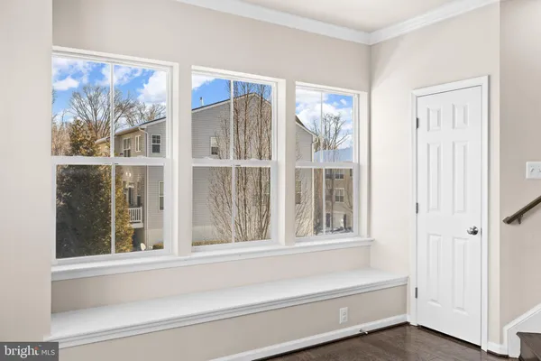 an empty room with chandelier fan and windows
