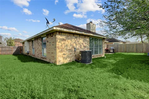 a view of backyard with barbeque grill and wooden fence