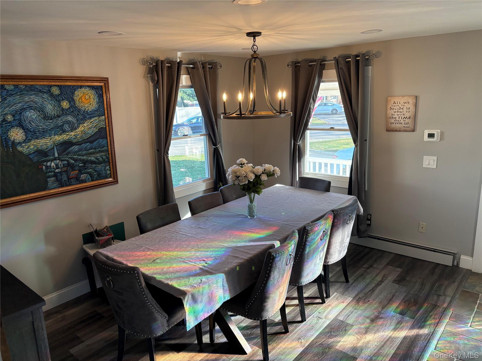 40 Alton Road Babylon, NY 11702 - Photo 13 of 41 Dining area featuring baseboard heating, a chandelier, dark wood-type flooring, and plenty of natural light