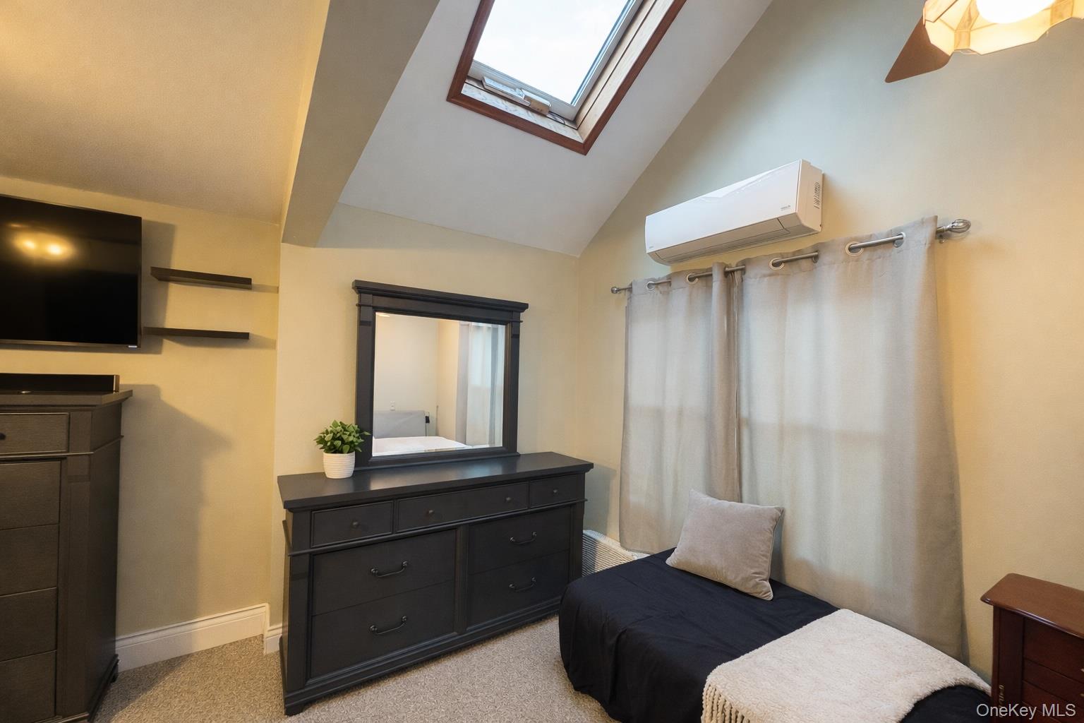 40 Alton Road Babylon, NY 11702 - Photo 21 of 41 Bedroom featuring lofted ceiling, carpet floors, a wall mounted AC, a skylight, and ceiling fan
