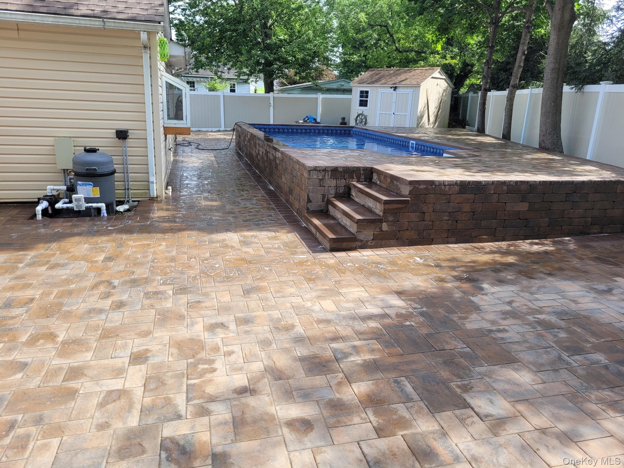 40 Alton Road Babylon, NY 11702 - Photo 9 of 41 View of pool in the summer,a patio, a storage unit, and a fenced backyard