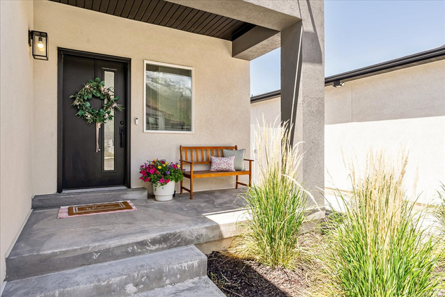 3916 South Sage Wood Avenue Mapleton, UT 84664 - Photo 5 of 33 Contemporary exterior featuring a solid black front door with a vertical glass insert, a complementary side window, and an overhead exterior light fixture