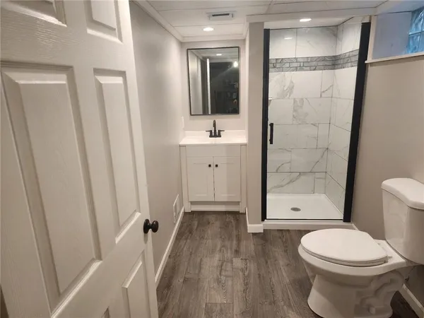 a bathroom with a sink a toilet and shower