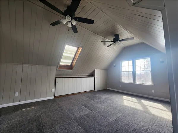 en empty room with windows and ceiling fan