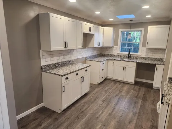 a kitchen with granite countertop white cabinets and white appliances