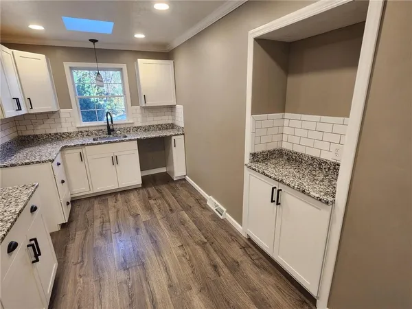 a kitchen with granite countertop white cabinets and white appliances