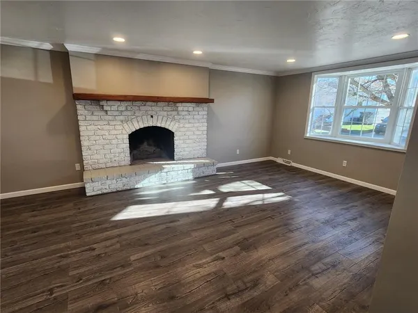 a view of a livingroom with a fireplace wooden floor and window