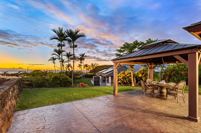 a view of a house with backyard and sitting area