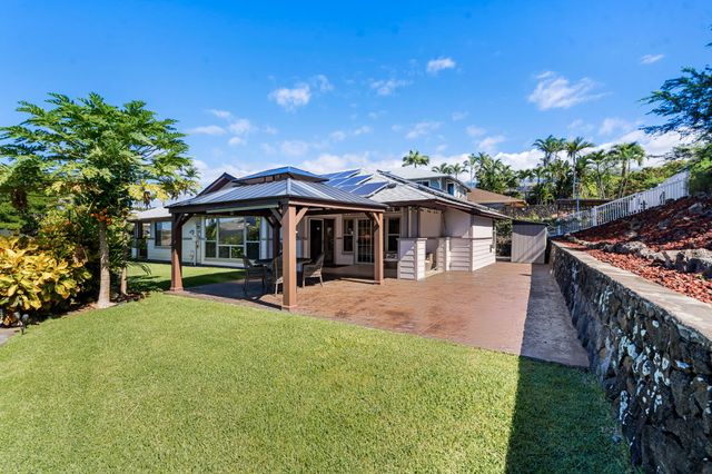 a view of a house with a yard and sitting area