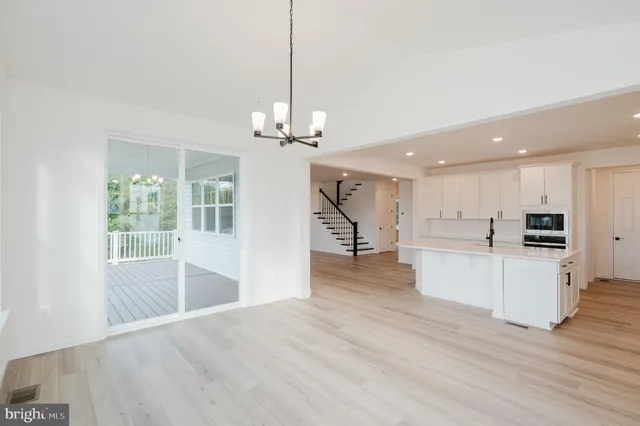 a view of a kitchen with kitchen island a counter top space a sink stainless steel appliances and cabinets