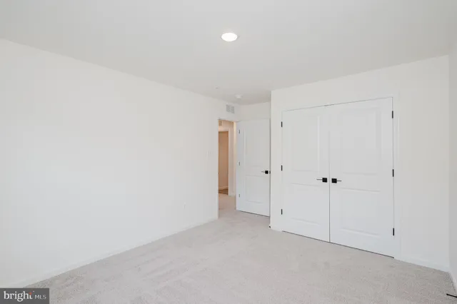 an empty room with windows and closet