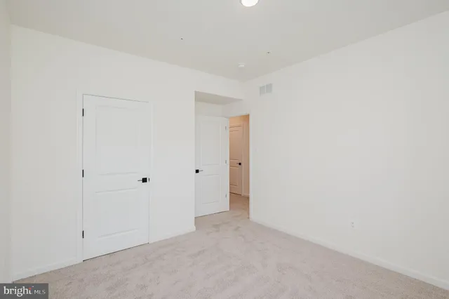 a view of a hallway with white walls and entryway