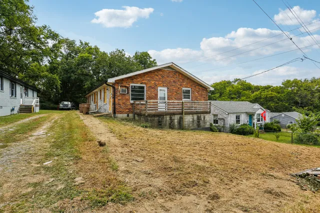 a front view of house with yard and trees around