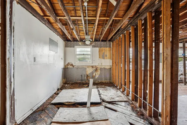 a room with lots of wooden furniture and windows