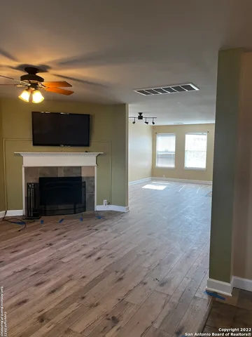 a view of empty room with wooden floor and fireplace