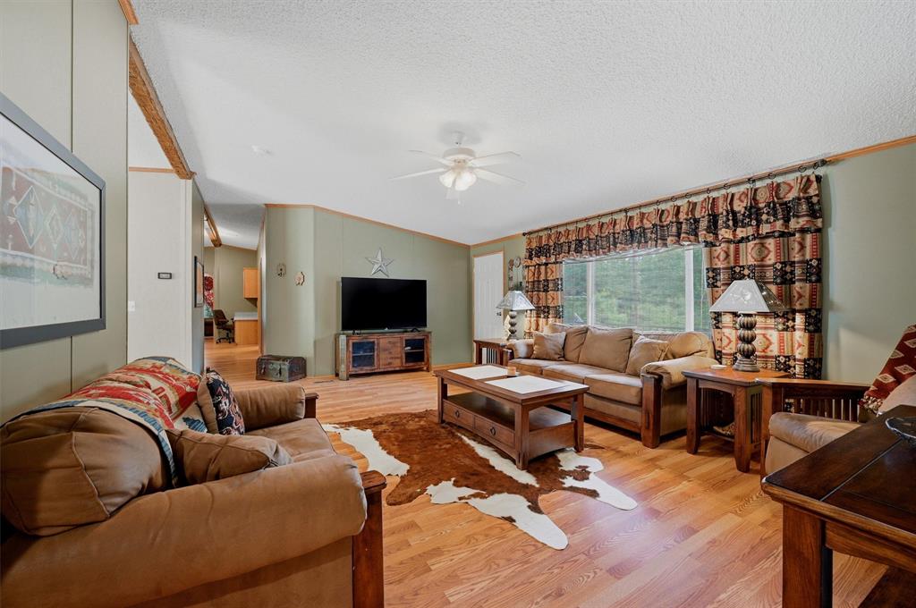 212 Sunset Road Pottsboro, TX 75076 - Photo 7 of 40 a living room with furniture ceiling fan and a flat screen tv
