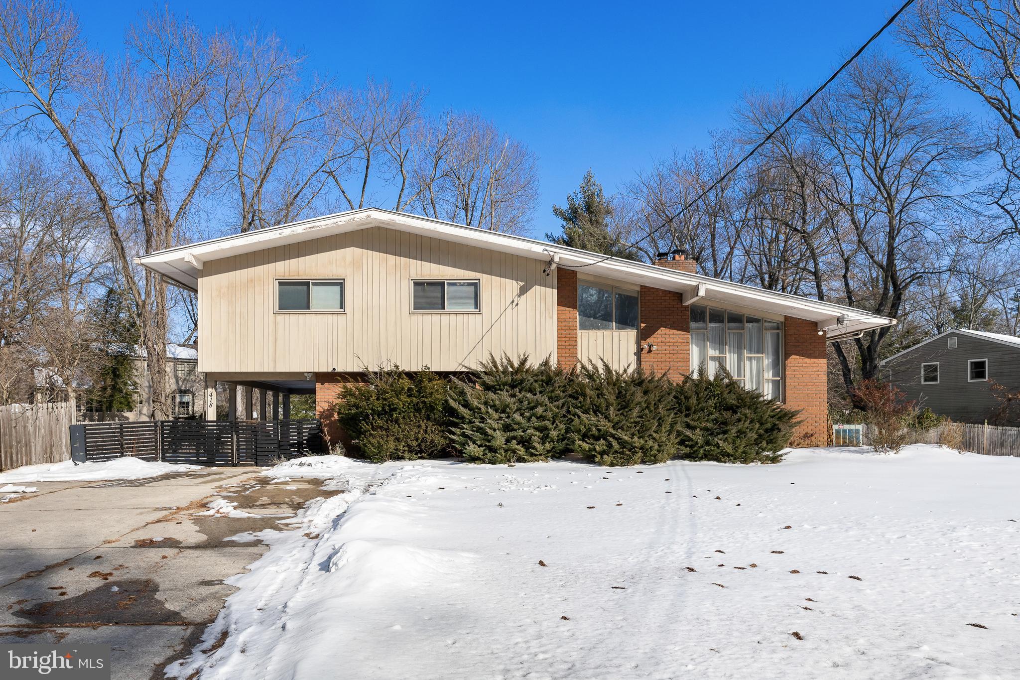 a front view of a house with a yard covered in snow