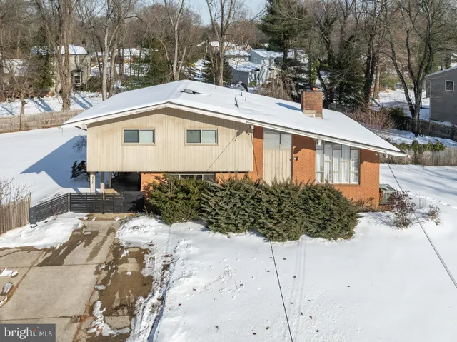 a front view of a house with a yard covered with snow