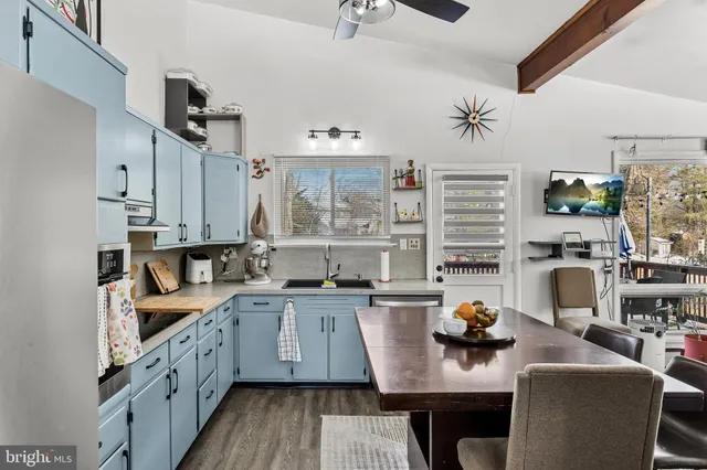 a kitchen with stainless steel appliances granite countertop a sink dishwasher a stove and a refrigerator with wooden floor