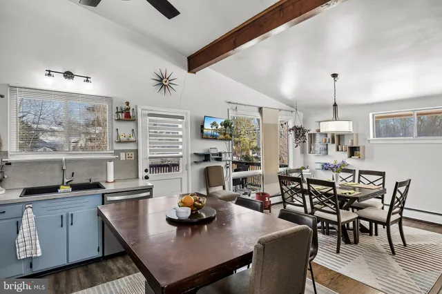 a view of a dining room and livingroom with furniture wooden floor a rug a chandelier
