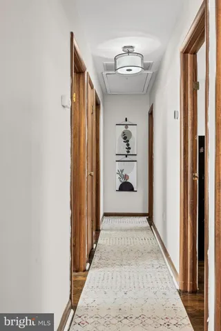 a view of hallway with a window and wooden floor
