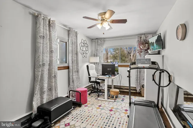 a view of a workspace with furniture and a window