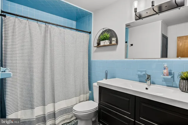 a bathroom with a sink a toilet and mirror