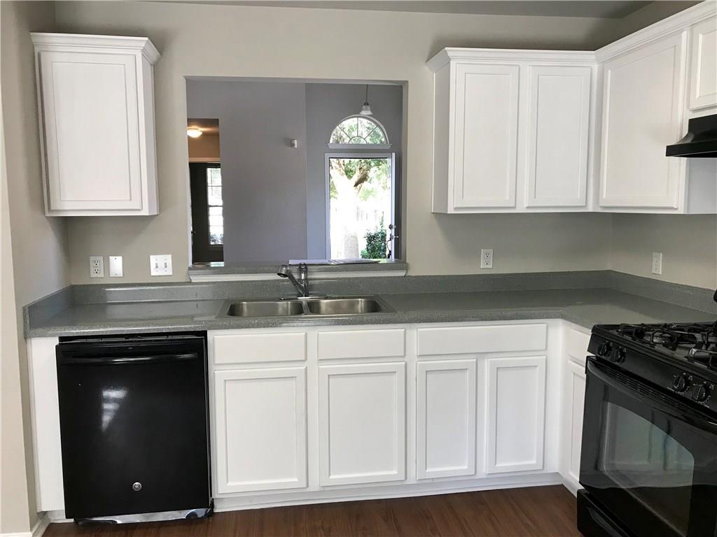 1251 Pine Portage Loop Leander, TX 78641 - Photo 8 of 17 a kitchen with white cabinets and a stove