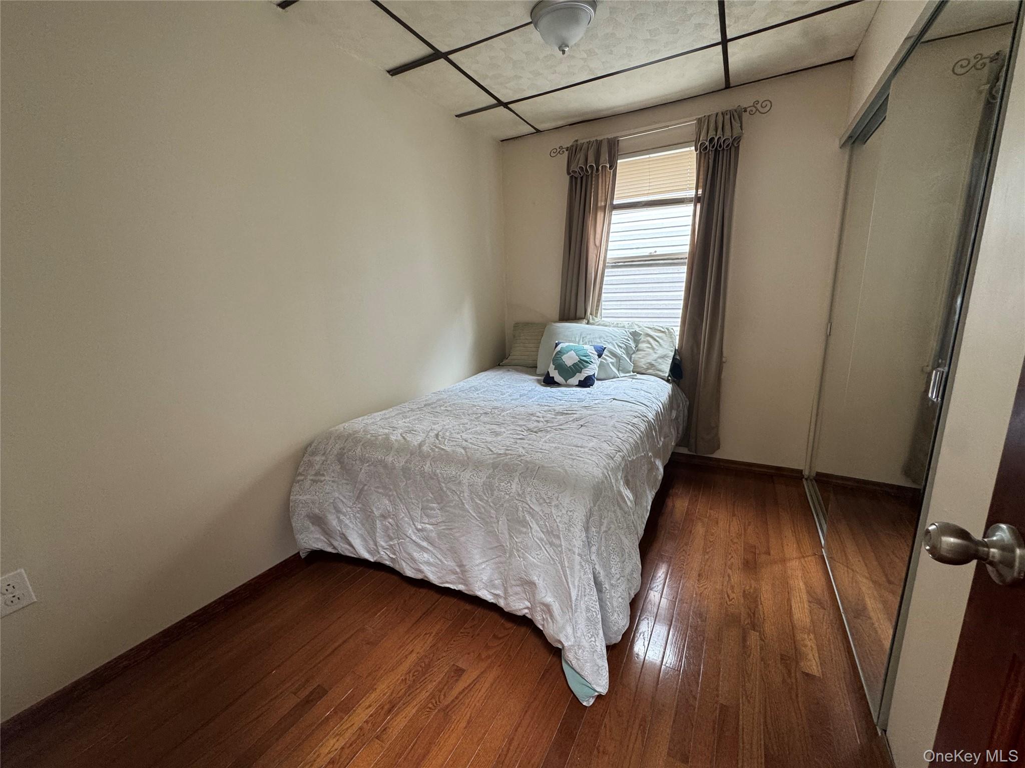 80-58 88th Road Queens, NY 11421 - Photo 14 of 21 a bedroom with a bed and a window