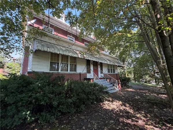 a front view of a house with a garden