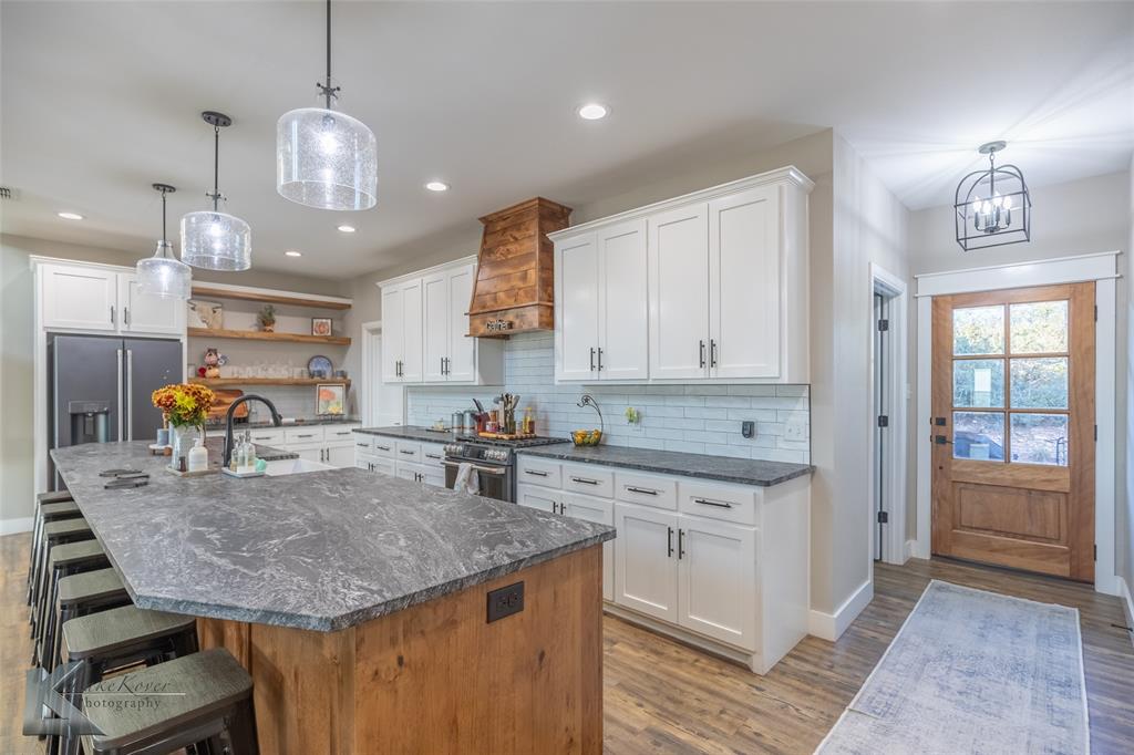 684 Taylor Ridge Estates Road Abilene, TX 79603 - Photo 9 of 39 a kitchen with a stove center island cabinets and wooden floor