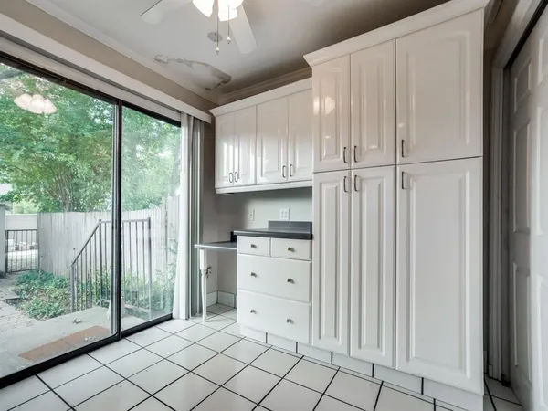 a kitchen with white cabinets and a window